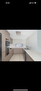 a large kitchen with white counter tops and appliances at 5 minute walk to the Stadium!! Taylord Holiday Homes and Apartments in Townsville