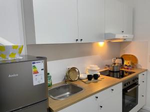 a kitchen with white cabinets and a sink at Place to sleep - Kassel: Direkt an der Uni in Kassel