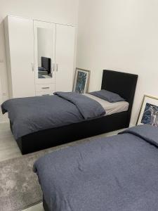 a bedroom with two beds and a cabinet with a television at Place to sleep - Kassel: Direkt an der Uni in Kassel