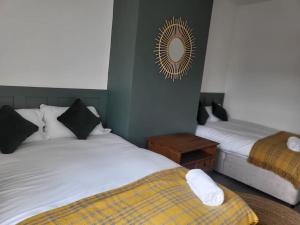 um quarto com 2 camas e um espelho na parede em Nice 2 bedroom (3 beds) house in Huddersfield em Lindley