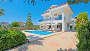a large white house with a swimming pool at Villa Lucia in Fethiye