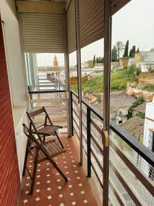 einen Stuhl auf einem Balkon mit Aussicht in der Unterkunft Piso luminoso y acogedor in Alcalá de Guadaira