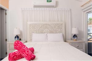 Un dormitorio con una cama blanca con una manta roja. en Marazul D1, en Westpunt