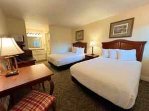 a hotel room with two beds and a desk at Best Western Country Lane Inn in Mendenhaven