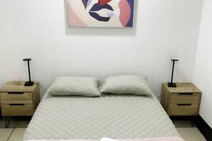 a bedroom with a bed with two night stands and a painting at Casa Colibrí Apartamento 5 in Guatemala
