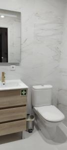 a white bathroom with a toilet and a sink at Caparica Apartment near beach in Costa da Caparica