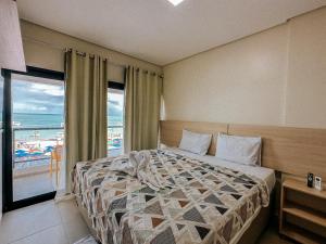 a bedroom with a bed with a view of the beach at Pousada Villa in Maragogi