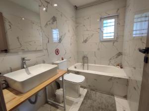 a bathroom with a sink and a tub and a toilet at Corfu Pintsis House 2 in Kompítsion
