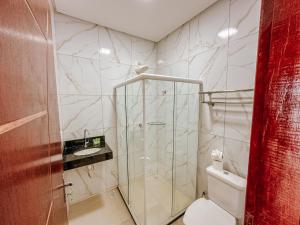 a bathroom with a shower with a toilet and a sink at Pousada Villa Barra Grande in Maragogi