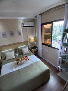 Un dormitorio con una cama con una bandeja de comida encima. en Flat Completo em Hotel 4 estrelas no Jardins! Com piscina, Jacuzzi, Sauna e academia!, en São Paulo 33 fotos más