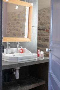 a bathroom with a sink and a mirror at Un appart. cosy au cœur d'Etel, à deux pas du port in Étel