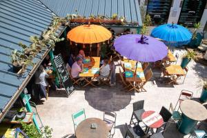 un gruppo di persone seduti in un ristorante con ombrelloni di Un appart. cosy au cœur d'Etel, à deux pas du port a Étel