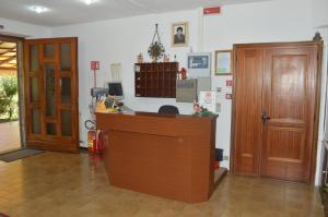 パッシニャーノ・スル・トラジメーノにあるHotel Belvedereのデスクと木製のドアが2つあるオフィス