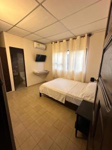 um quarto com uma cama e uma janela com cortinas em Hotel Almirante Padilla em Ríohacha