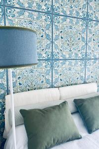 a room with a couch and a wall with blue tiles at About Italy Holiday Rooms and Apartments in Portovenere