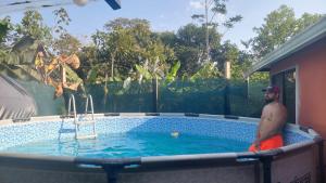 a man is standing in a swimming pool at El Encanto Caño Negro in Caño Negro