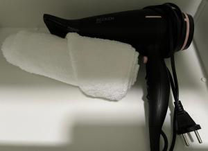 a black blow dryer with a roll of paper towels at Primeiro Quartel Apartments - 5 in Peso da Régua