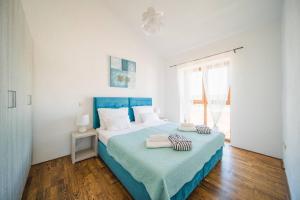 - une chambre avec un lit bleu et blanc et une fenêtre dans l'établissement Villa Mani, à Butkovići