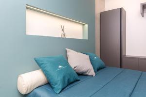 a blue bed with blue pillows and a mirror at Le note di Fred Rent Room in Campobasso