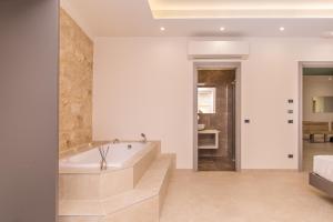 a large bathroom with a tub and a bedroom at Le note di Fred Rent Room in Campobasso