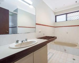 a bathroom with a sink and a tub and a mirror at Queen Size Bedroom Near Sawn River in Perth