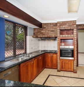une cuisine avec un évier et une cuisinière four supérieur dans l'établissement Long Term Stay FiFO Queen Size Bedroom Near Sawn River City Fremantle University, à Perth