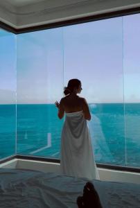 a woman in a white dress standing in front of a window at condostmaarten by the sea in Koolbaai