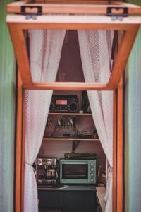 einen Schrank mit einer Mikrowelle und einem Radio darin in der Unterkunft Relax Homestay at the foot of the Great Wall in Huairou