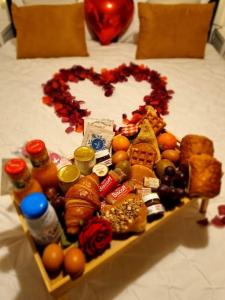a heart made out of food on a bed at Gite avec jacuzzi privé in Arnières-sur-Iton