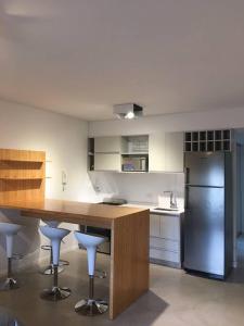 a kitchen with a counter with stools and a refrigerator at Excelente estudio premium con amenities in Buenos Aires