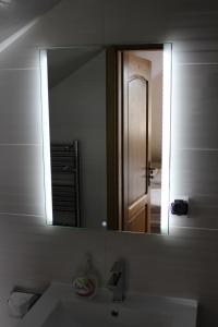 a bathroom mirror with a sink and a door at Stary Zajazd in Zielona Góra