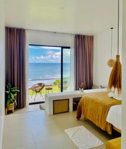 a bedroom with a bed and a view of the ocean at Trogon's Perch in San Isidro