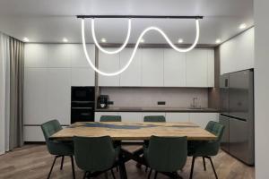 a dining room with a table and green chairs at Pratamnak apartment Andromeda complex near beach in Pattaya South