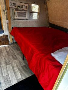 a red bed in the back of a tiny house at Black castle RV2 in Miami