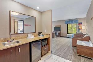 Hampton Inn & Suites Orlando-Apopka في أورلاندو: غرفة مع مطبخ مع حوض ومرآة