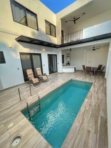 a pool in a room with chairs and a table at CASA SAN AGUSTÍN #4 in Puerto Escondido