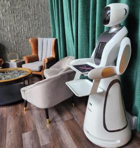 a white robot sitting in a room with a couch at Pinnacle Suites in Cowes
