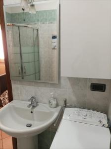 W łazience znajduje się umywalka i lustro. w obiekcie Casa Angela Parma w mieście Parma