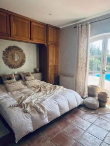 ein Schlafzimmer mit einem großen Bett und einem großen Fenster in der Unterkunft Luxe Villa in Grimaud in Grimaud