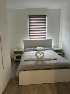 Schlafzimmer mit einem Bett mit Herzdekoration in der Unterkunft EEJs Modern 3 bed flat near Crystal Palace Stadium with great transport links in Norwood