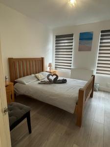 ein Schlafzimmer mit einem Bett mit einer Lampe in der Unterkunft EEJs Modern 3 bed flat near Crystal Palace Stadium with great transport links in Norwood