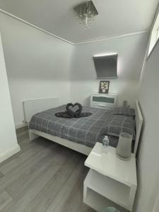ein kleines Schlafzimmer mit einem Bett und einem Tisch in der Unterkunft EEJs Modern 3 bed flat near Crystal Palace Stadium with great transport links in Norwood