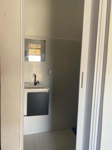 La petite salle de bains est pourvue d'un lavabo et d'un miroir. dans l'établissement Kit net linda e aconchegante, à Cabo Frio