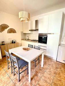 a kitchen with a white table and chairs in it at Casa Vacanze La Baia in Messina