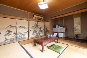 Habitación con mesa y dibujos en las paredes. en Nosecho Guest House - Vacation STAY 14366 en Kawabe