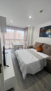 una camera bianca con un grande letto e un tavolo di Madrid House Boutique , Aeropuerto , Ifema a Madrid