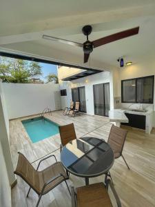 a living room with a table and chairs and a pool at CASA SAN AGUSTÍN #4 in Puerto Escondido