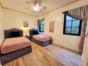 a bedroom with two beds and a ceiling fan at Encanto! Enchanted 3 bedroom private home near LACMA in Los Angeles