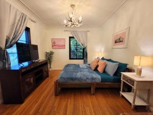 1 dormitorio con 1 cama y TV de pantalla plana en Encanto! Enchanted 3 bedroom private home near LACMA, en Los Ángeles