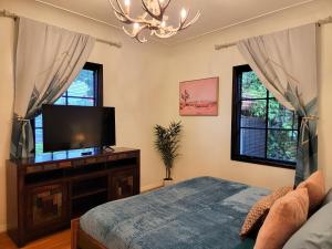 1 dormitorio con 1 cama y TV de pantalla plana en Encanto! Enchanted 3 bedroom private home near LACMA, en Los Ángeles